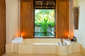 The expansive, terrazzo-tiled bathroom comes with a shower and deep soaking tub, a window-side divan, double terrazzo vanities and twin coconut-wood dressing areas.